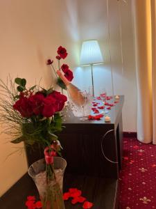 una mesa con copas de vino y flores. en Top Royal Central Brasov en Brasov