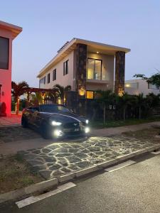 a black car parked in front of a house at Green Creek Villa in Flic-en-Flac