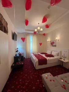 1 dormitorio con 2 camas y corazones rojos en el techo en Top Royal Central Brasov en Brasov