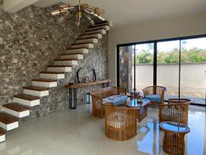sala de estar con escalera, mesas y sillas en Green Creek Villa, en Flic en Flac