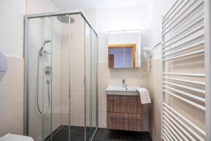 a bathroom with a glass shower and a sink at Appartements Baumanngut in Wagrain +116 photos