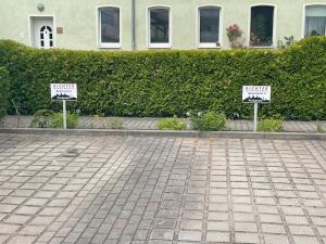 two signs on a sidewalk in front of a building at Richter Apartments 3 in Finsterwalde