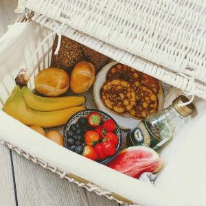 a basket filled with different types of fruits and vegetables at Volledig gerenoveerde luxe gastsuite met ontbijt in Vlissingen
