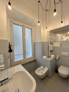 bagno bianco con lavandino e servizi igienici di MaMa a La Spezia