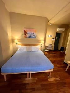 um quarto com uma cama grande e um cobertor azul em MaMa em La Spezia