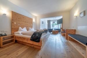 ein Schlafzimmer mit einem großen Bett und einer Holzwand in der Unterkunft Alpin Art & Spa Hotel Naudererhof Superior in Nauders