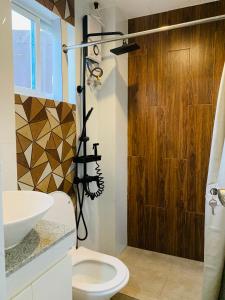 a bathroom with a shower and a toilet and a sink at Cozy Unit at the heart of Balanga City in Balanga