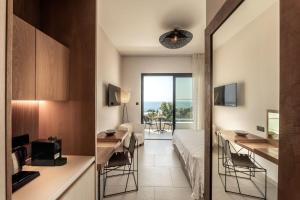 a hotel room with a bed and a dining table and chairs at Anemi Hotel & Suites in Paphos City