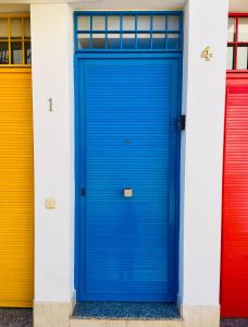 a blue door in a group of colorful doors at Apartamentos Chuita Playa in Málaga