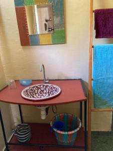 a bathroom with a red counter with a sink at Villa Rose in Bobo-Dioulasso