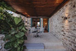 Lefkara Luxury Suites في بانو يفكارا: فناء مسور حجري مع طاولة وكراسي