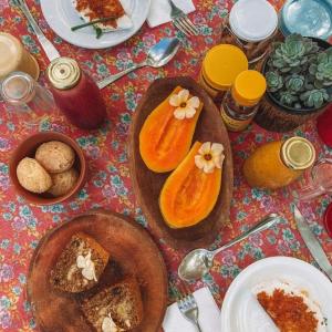 una mesa con platos de comida en una mesa en Canto de Jurema Corumbau Glamping, Chalé, Acolhimento e Sustentabilidade, en Corumbau