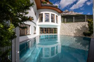 a house with a swimming pool and a building at Hotel Sonnalp 4 Sterne Superior in Obereggen