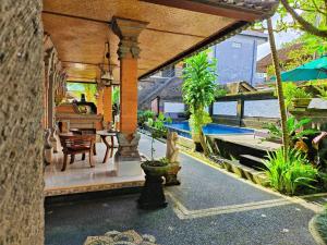 Warji House 2 Bisma في أوبود: فناء مع طاولة وكراسي ومسبح