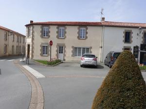 Un coche aparcado en un estacionamiento frente a un edificio. en Gite de la fontaine Marsi, en Saint-Mars-la-Réorthe