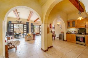 a large kitchen with arches and a living room at Razzett ta' Leli Holiday Home in Xagħra