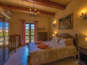 a bedroom with a bed and a large window at Razzett ta' Leli Holiday Home in Xagħra