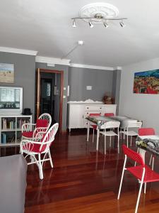 a living room with red chairs and a table at A Barca de Pedra in Padrón