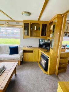 a living room with a couch and a table at Rowanlea Caravan in Stonehaven