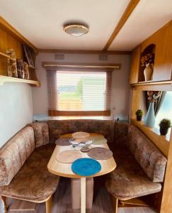 a living room with a table and a couch at Rowanlea Caravan in Stonehaven