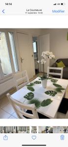 a white dining room table with a plant on it at Gite Mella in La Courneuve