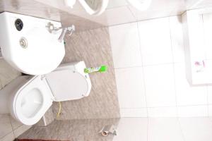 a white bathroom with a toilet and a sink at Rorot 2 bdrm stay located Annex home away(bright) in Eldoret +16 photos
