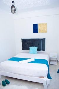 a bedroom with a white bed with blue accents at Rorot 2 bdrm stay located Annex home away(bright) in Eldoret