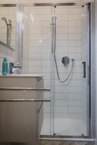 a shower with a glass door in a bathroom at [CATHEDRAl] elegant apartment in Parma