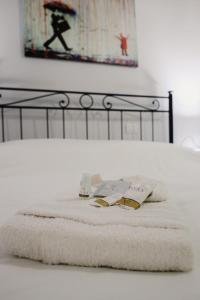 ein Bett mit weißen Handtüchern und einem schwarzen Rahmen in der Unterkunft [CATHEDRAl] elegant apartment in Parma