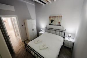 a bedroom with a white bed with two towels on it at [CATHEDRAl] elegant apartment in Parma