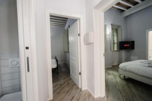 um quarto com paredes brancas, uma cama e uma televisão em [CATHEDRAl] elegant apartment em Parma