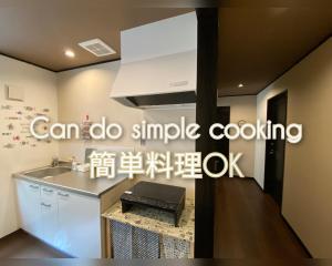 uma cozinha com um lavatório e um fogão em Guesthome Machiya Koza em Okinawa