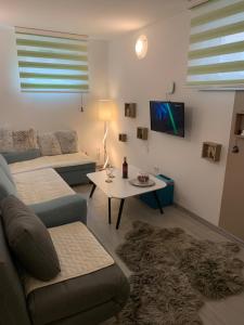 una sala de estar con un sofá y una mesa en Apartman Mont, Lux & Jacuzzi - Jahorina, en Jahorina