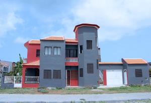 a red and gray house with a red roof at Escape House in Tarrafal