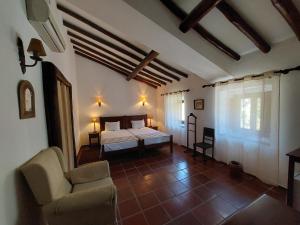 - une chambre avec un lit et une chaise dans l'établissement Convento da Provença, à Portalegre