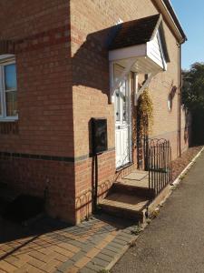 a front door of a brick house with a porch at 59 Halstead - Gorgeous single bedroom with private bathroom in Halstead