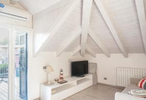 een woonkamer met witte plafonds en een televisie bij A casa di Oscar in Deiva Marina