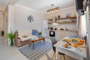 uma cozinha e sala de estar com uma mesa e um sofá em Acacia APT by Aglaia V em Vlachopoulátika