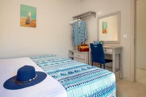 a bedroom with a bed with a blue hat on it at Acacia APT by Aglaia V in Vlachopoulátika