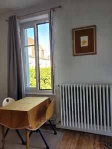 a table and chair in a room with a window at Studio19 in Clermont-Ferrand
