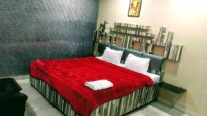 Schlafzimmer mit einem Bett mit roter Bettwäsche und weißen Kissen in der Unterkunft THE PRESTIGE HOTEL & CONVENTION in Rourkela