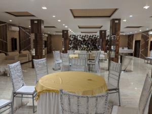 una sala da pranzo con tavolo e sedie gialli di THE PRESTIGE HOTEL & CONVENTION a Rourkela