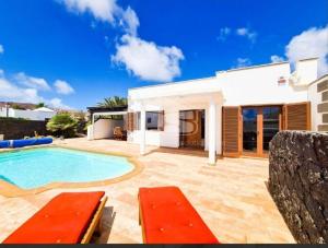 a villa with a swimming pool and a house at VILLA ANGELINA in Playa Blanca