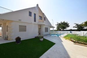 a house with a lawn and a swimming pool at וילת קסם הזוהר- ניר יפה in Nir Yafe