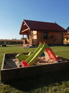een speeltuin met een glijbaan in een zandbak bij Bella Przystań in Zator