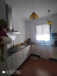 una cocina con armarios blancos y un dinosaurio de juguete en el medio en Agradable casa rural con chimenea y buenas vistas, en Cañaveral de León