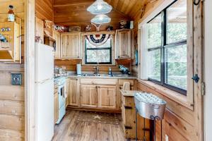 een keuken met houten kasten en een koelkast bij Rock of Ages Cabin at Amazing Grace Canyon in Luckenbach