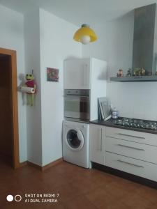 uma cozinha com uma máquina de lavar roupa e uma máquina de lavar roupa em Agradable casa rural con chimenea y buenas vistas em Cañaveral de León