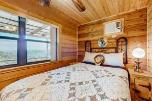 een slaapkamer met een bed en een raam bij Rock of Ages Cabin at Amazing Grace Canyon in Luckenbach