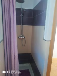 y baño con ducha con cortina púrpura. en Agradable casa rural con chimenea y buenas vistas, en Cañaveral de León